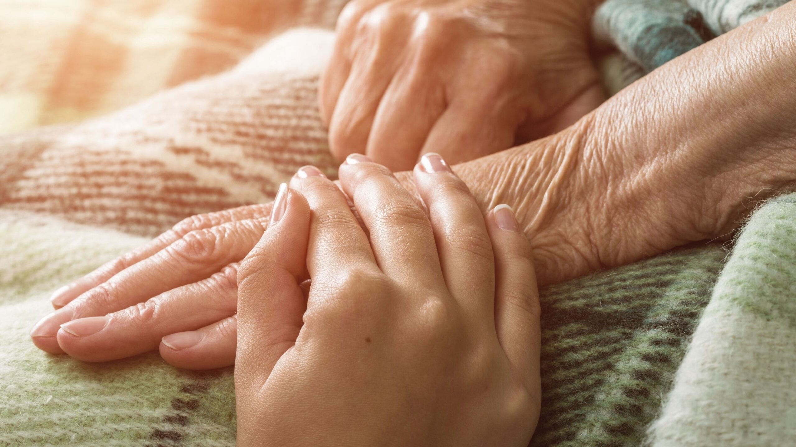 One person is holding a hand on another person's hand.