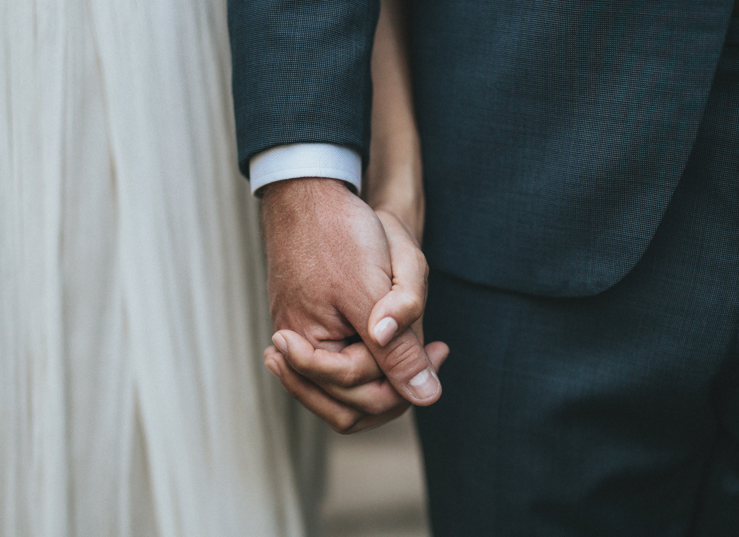 A bride and groom holding hands.