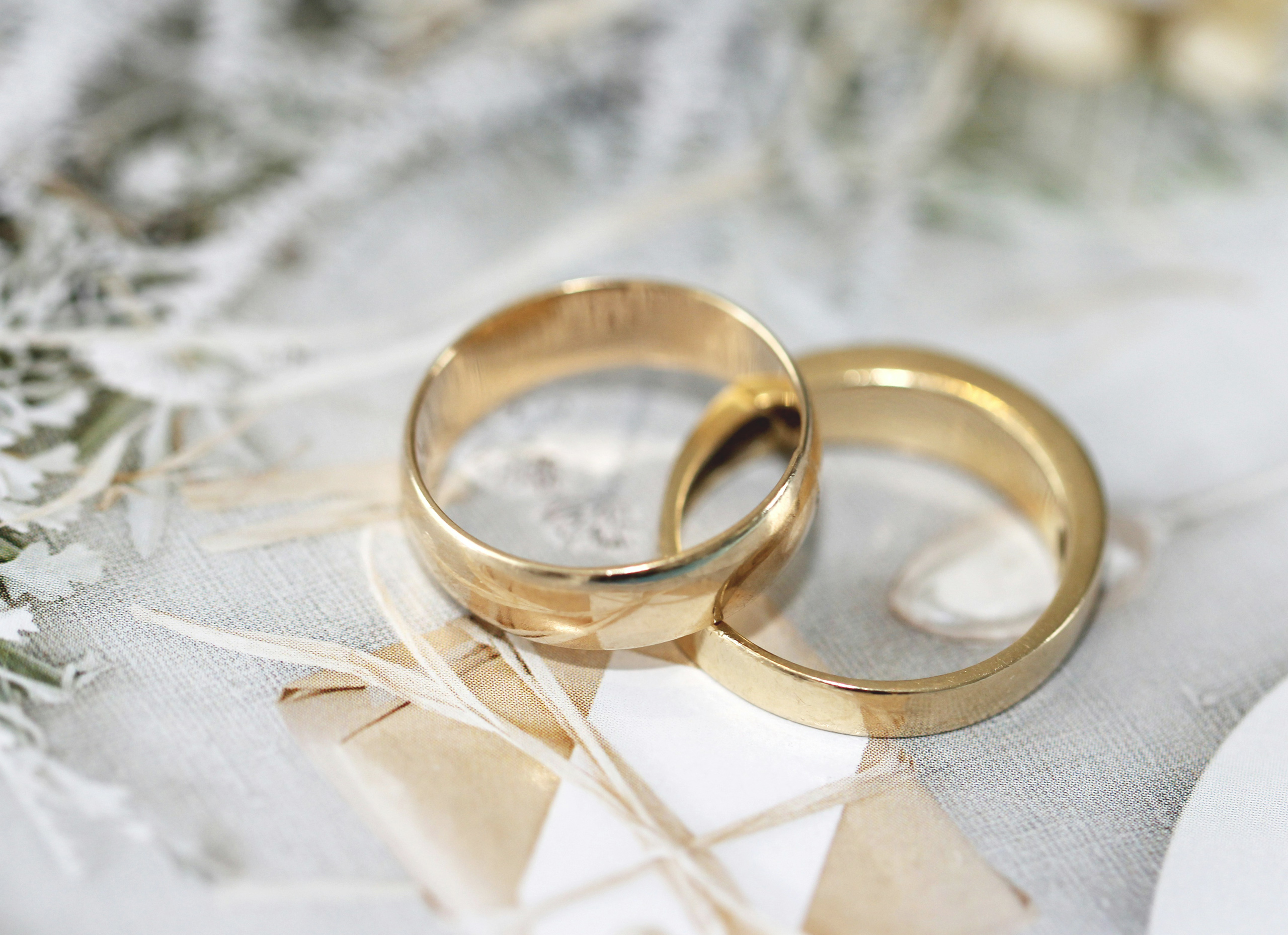 Two golden wedding rings, partially on top of each other.