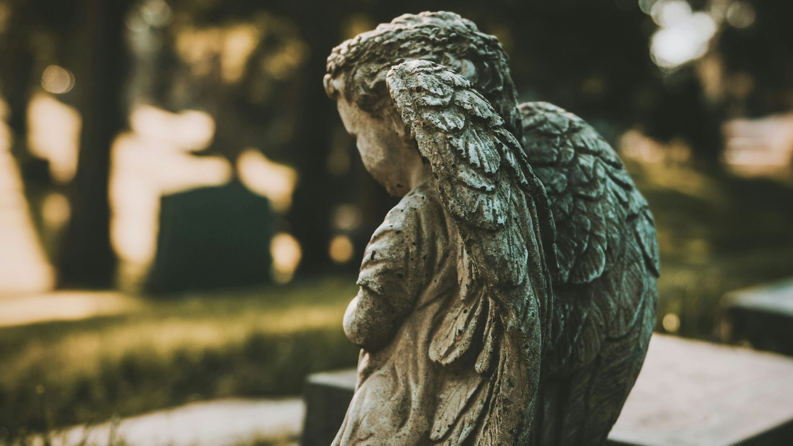 Statue of a small child with angel wings, on a graveyard.