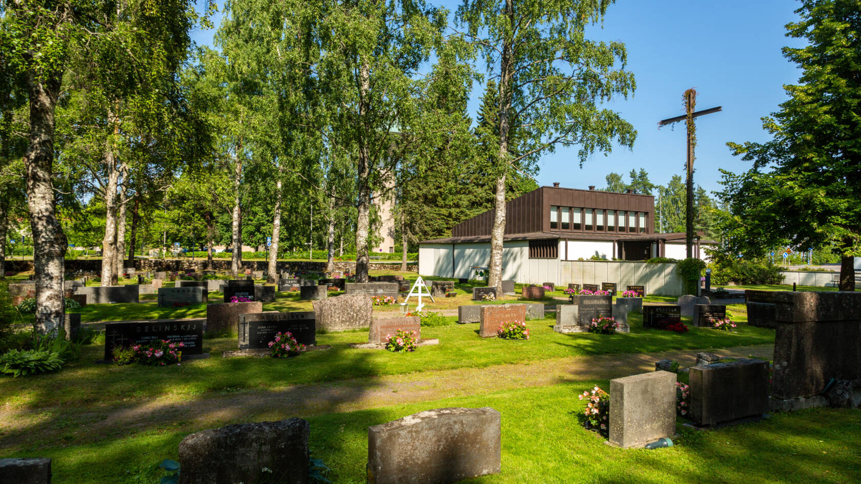 Kesäinen kuva Joutsenon uudelta hautausmaalta. Oikealla kappeli ja risti.