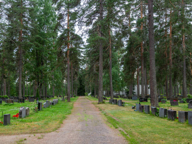 Käytvä, jonka kahta puolta hautakiviä ja puita