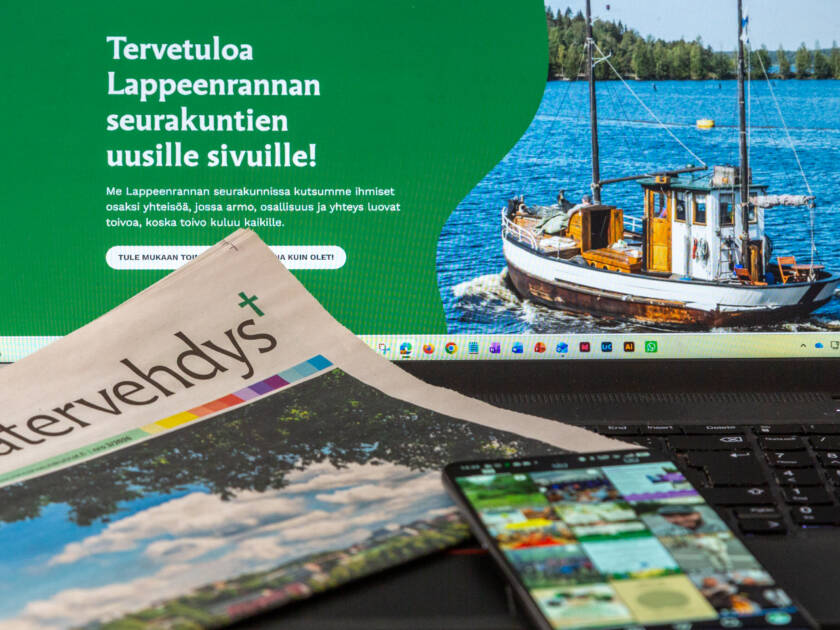 kannettavan tietokoneen näyttö, Seurakuntatervehdys-lehti ja matkapuhelin, jonka näytöllä Instagram kuvasyöte.